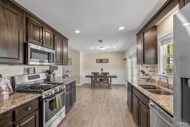 kitchen featuring dark brown cabinetry, appliances with stainless steel finishes, and a sink