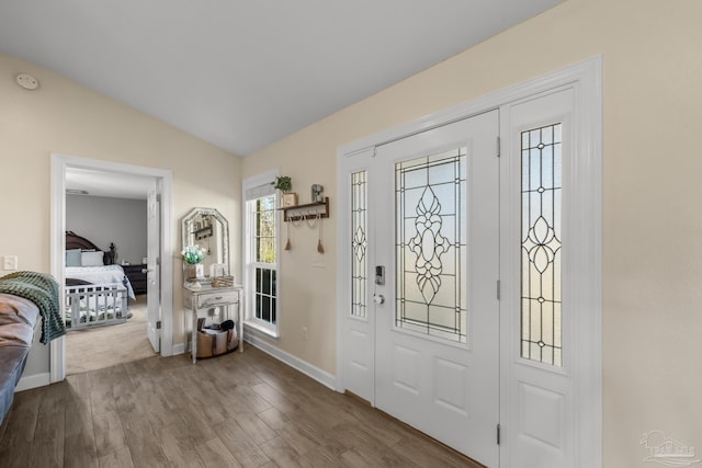 entrance foyer featuring baseboards, lofted ceiling, and wood finished floors