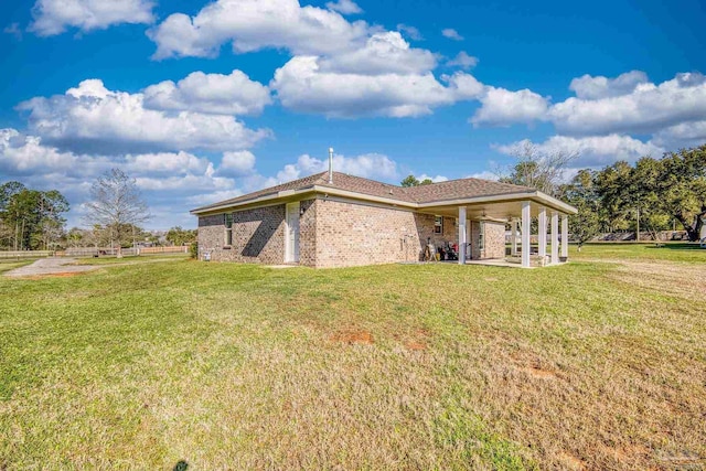 view of side of property featuring a yard, a patio, and brick siding