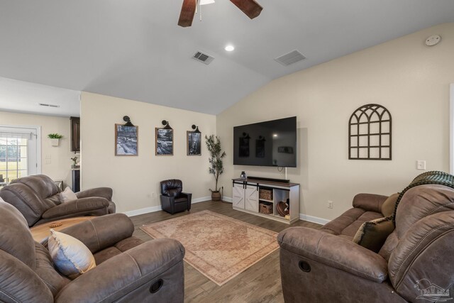 living area with visible vents, baseboards, lofted ceiling, and wood finished floors