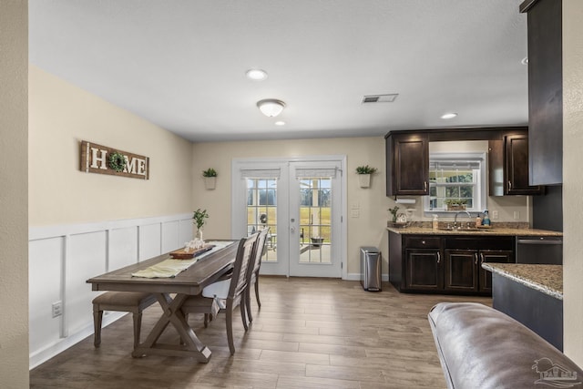 dining room with wood finished floors, visible vents, recessed lighting, french doors, and wainscoting