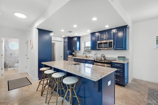 1299 Ft Pickens Rd Unit 6, Pensacola Beach, FL 32561 - kitchen featuring a breakfast bar area, light stone countertops, visible vents, blue cabinetry, and appliances with stainless steel finishes