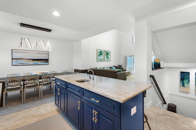 1299 Ft Pickens Rd Unit 6, Pensacola Beach, FL 32561 - kitchen with blue cabinets, an island with sink, a sink, light stone countertops, and vaulted ceiling
