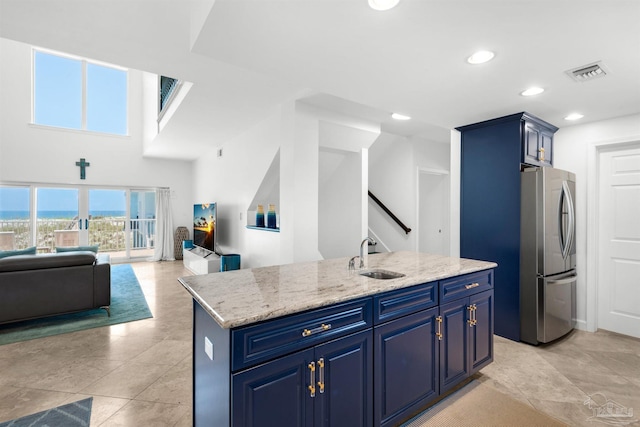 1299 Ft Pickens Rd Unit 6, Pensacola Beach, FL 32561 - kitchen featuring visible vents, blue cabinetry, freestanding refrigerator, a sink, and open floor plan