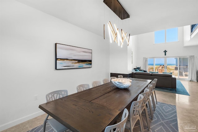 1299 Ft Pickens Rd Unit 6, Pensacola Beach, FL 32561 - dining room with light tile patterned floors, a high ceiling, and baseboards