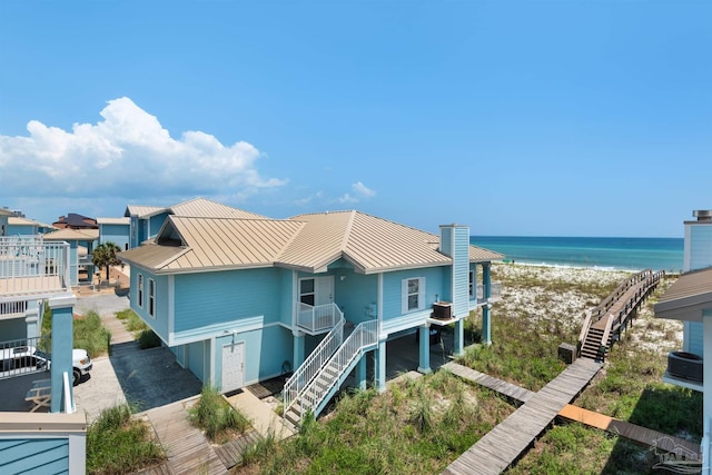 1299 Ft Pickens Rd Unit 6, Pensacola Beach, FL 32561 - view of front facade featuring stairway, metal roof, a standing seam roof, and a water view