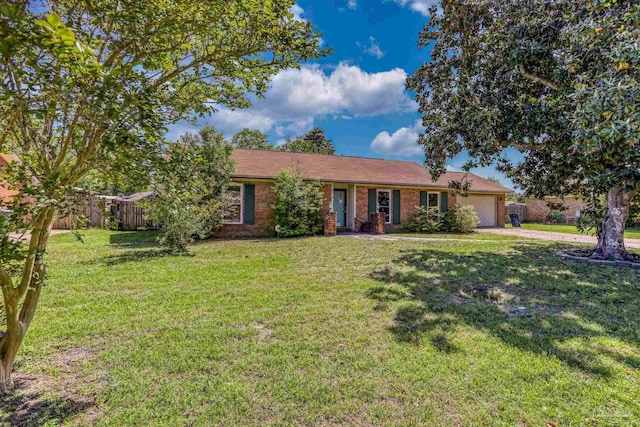 ranch-style home featuring fence, a front lawn, brick siding, an attached garage, and driveway