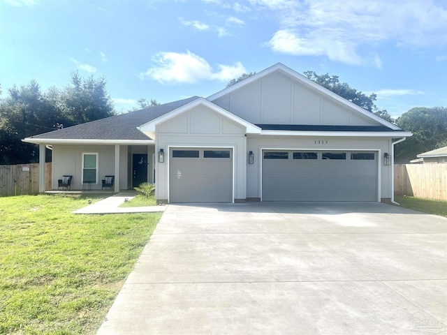 1315 W Scott St, Pensacola, FL 32501 - ranch-style house with a front yard, a garage, board and batten siding, concrete driveway, and fence
