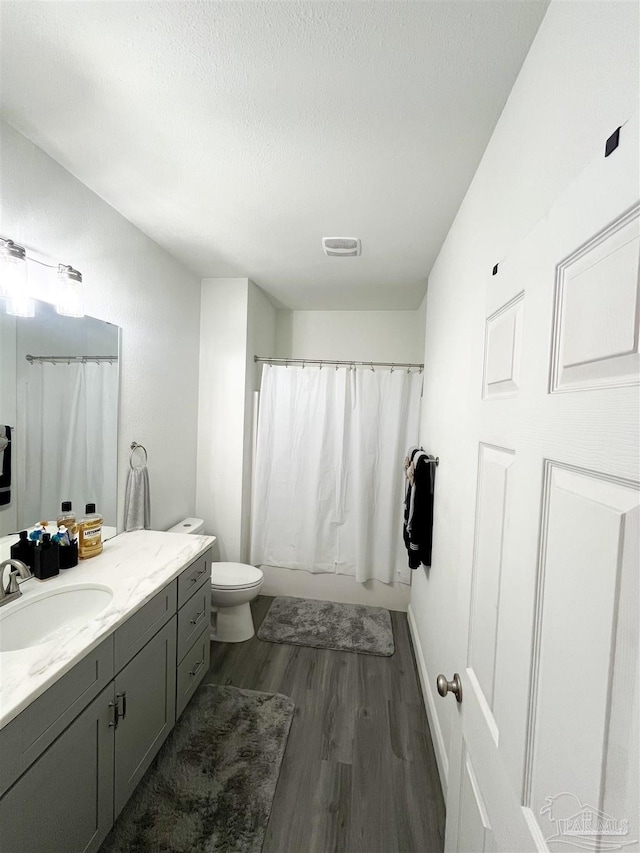 1315 W Scott St, Pensacola, FL 32501 - bathroom with vanity, toilet, visible vents, a textured ceiling, and wood finished floors