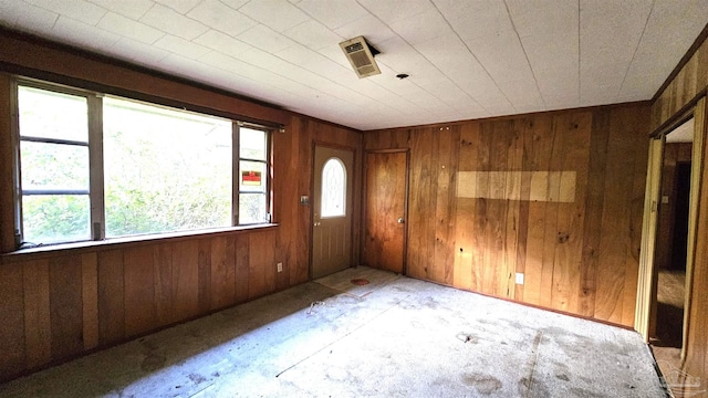 unfurnished room featuring wood walls