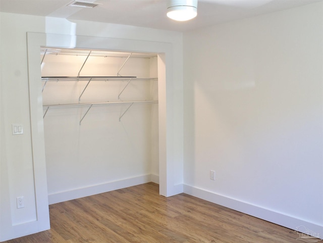 unfurnished bedroom with a closet, baseboards, and wood finished floors