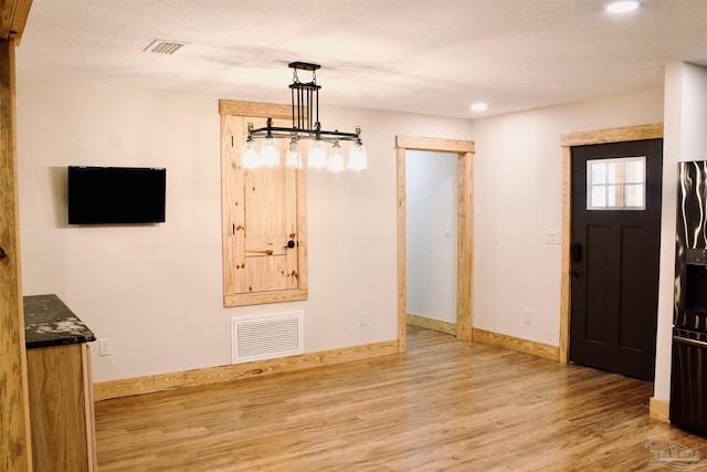 unfurnished dining area featuring recessed lighting, wood finished floors, visible vents, and baseboards