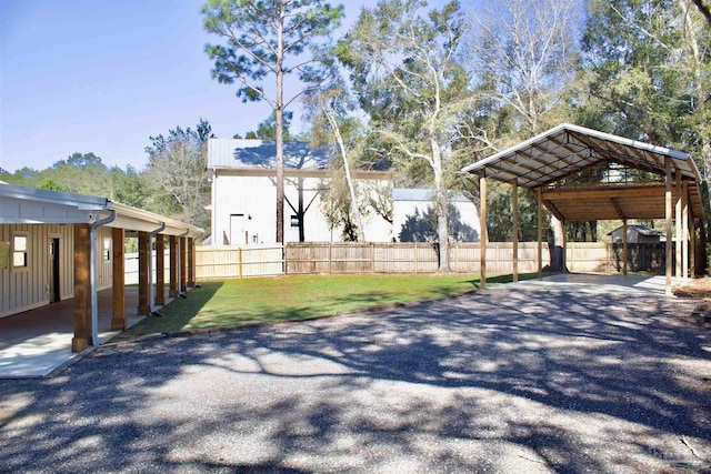 exterior space with fence, aphalt driveway, and a carport