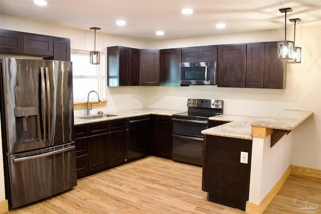 kitchen featuring a peninsula, stainless steel appliances, dark brown cabinets, light wood-type flooring, and a sink