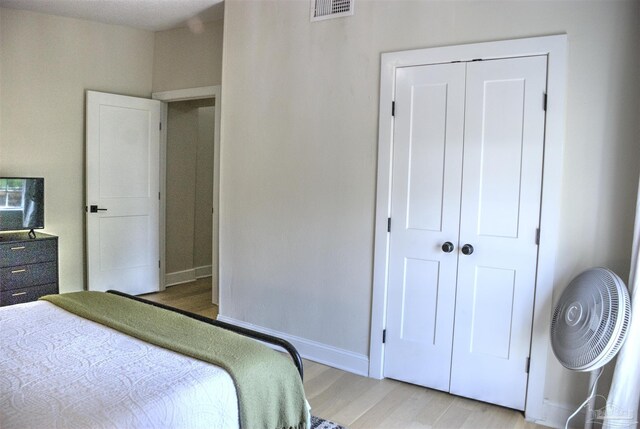 bedroom with light wood-type flooring and a closet