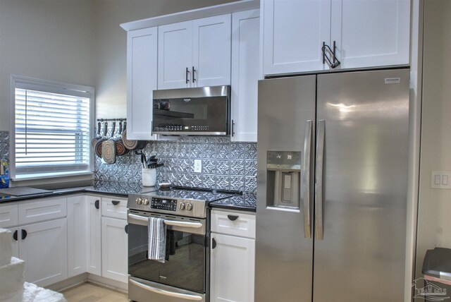 kitchen with white cabinetry, stainless steel appliances, and decorative backsplash