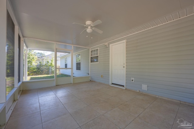 unfurnished sunroom with ceiling fan