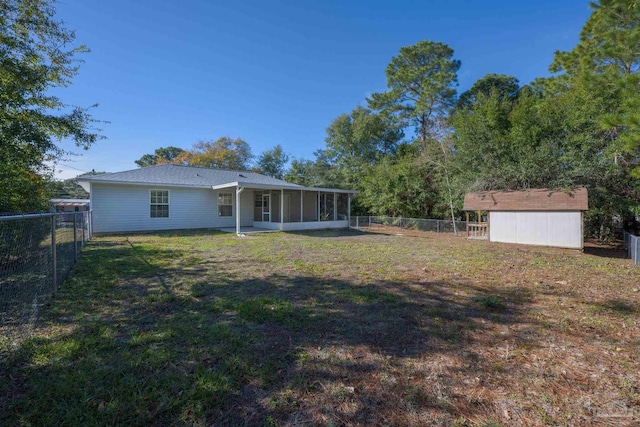 view of yard featuring a sunroom and a storage unit