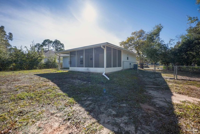 rear view of house with a sunroom and a yard