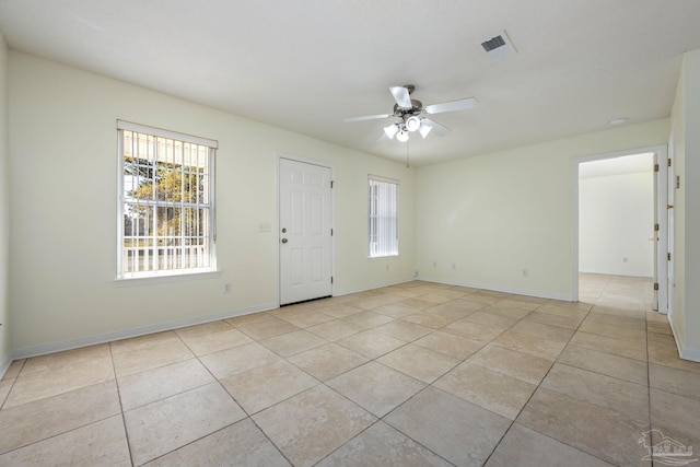 empty room with ceiling fan and light tile patterned flooring