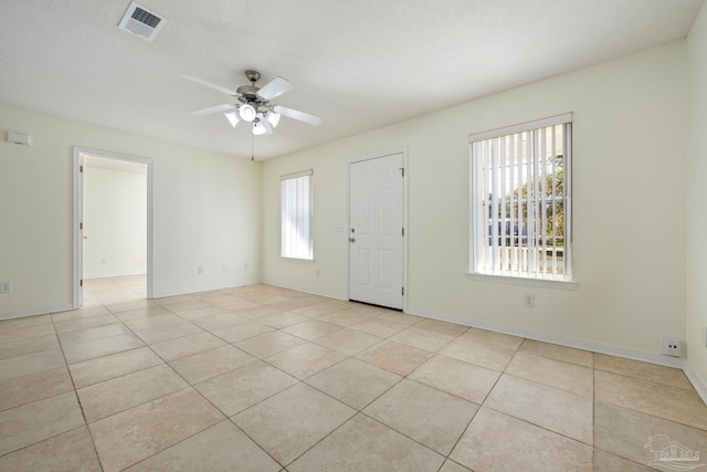 foyer with ceiling fan, light tile patterned floors, and a textured ceiling