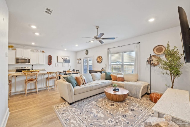 living room featuring ceiling fan and light wood-type flooring