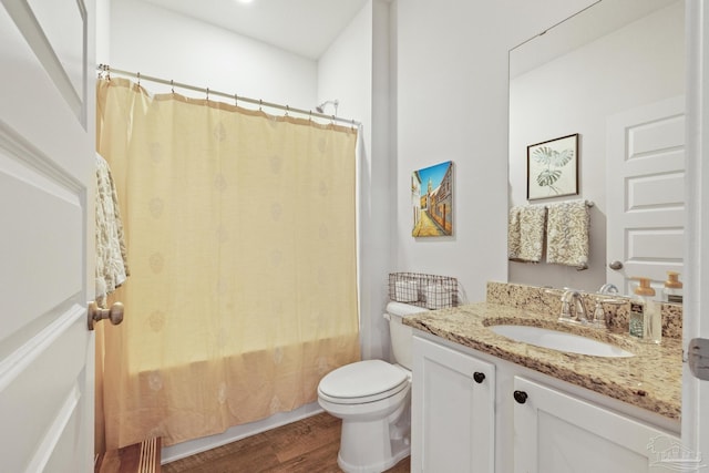 full bathroom with wood-type flooring, shower / tub combo, vanity, and toilet