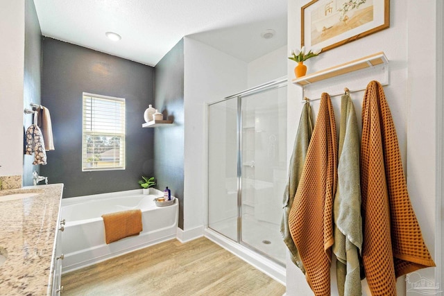 bathroom with vanity, hardwood / wood-style floors, and shower with separate bathtub