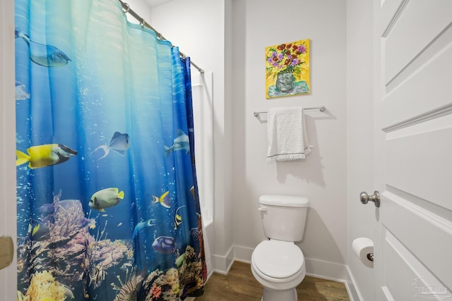 bathroom with wood-type flooring, toilet, and curtained shower