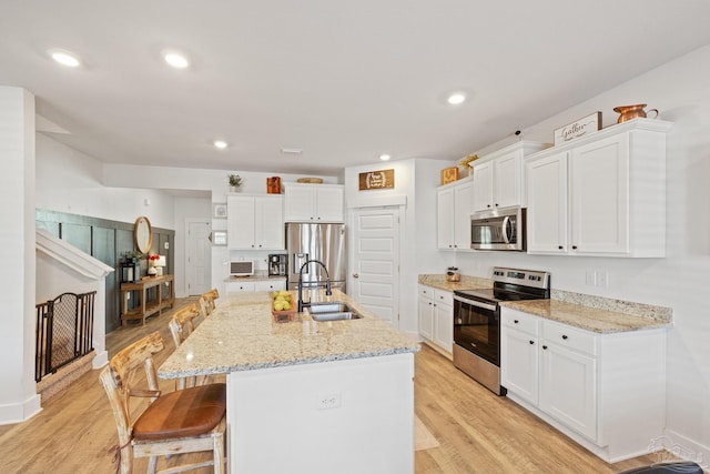 kitchen with white cabinetry, sink, a center island with sink, and appliances with stainless steel finishes