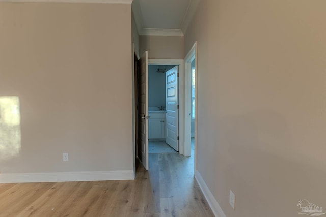 hall with ornamental molding and light wood-type flooring