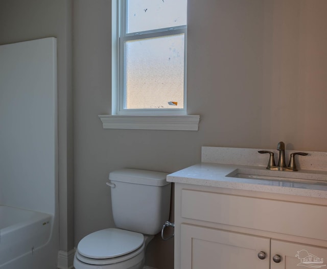 bathroom with vanity, a bathtub, and toilet