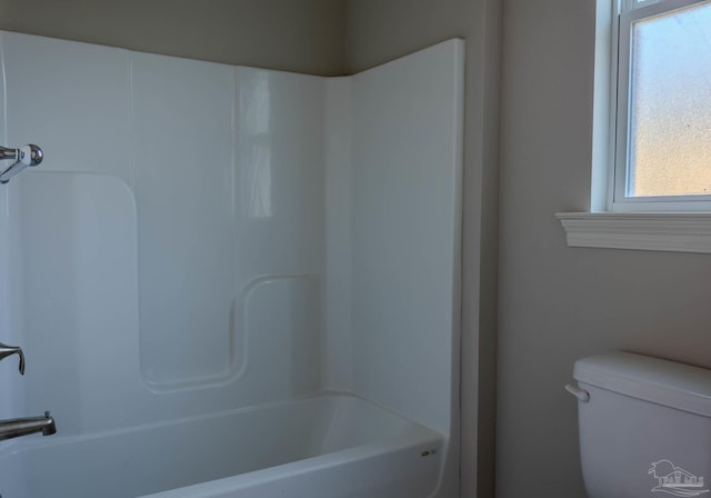 bathroom with bathing tub / shower combination and toilet