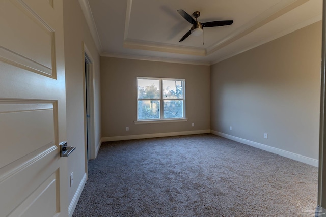 carpeted spare room featuring crown molding, a tray ceiling, and ceiling fan