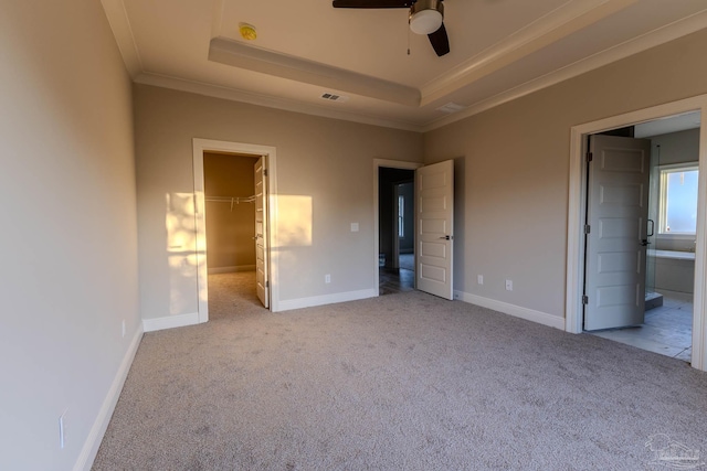 unfurnished bedroom featuring a walk in closet, a closet, light colored carpet, and connected bathroom