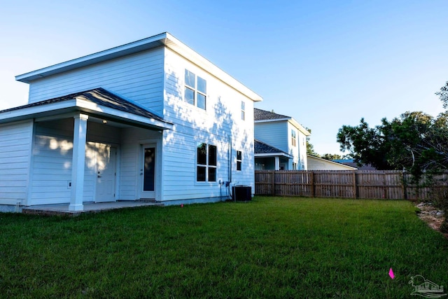 back of house featuring central AC and a lawn