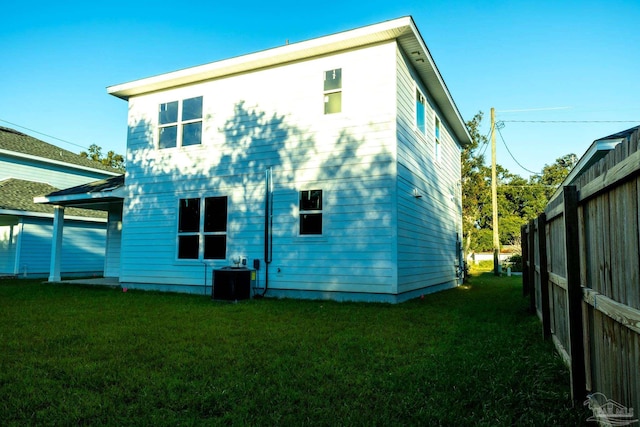 back of house with a lawn and central AC unit