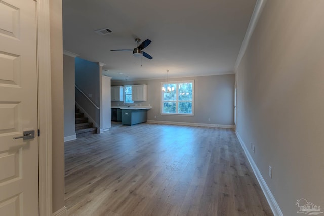 unfurnished living room featuring crown molding, wood-type flooring, and ceiling fan with notable chandelier