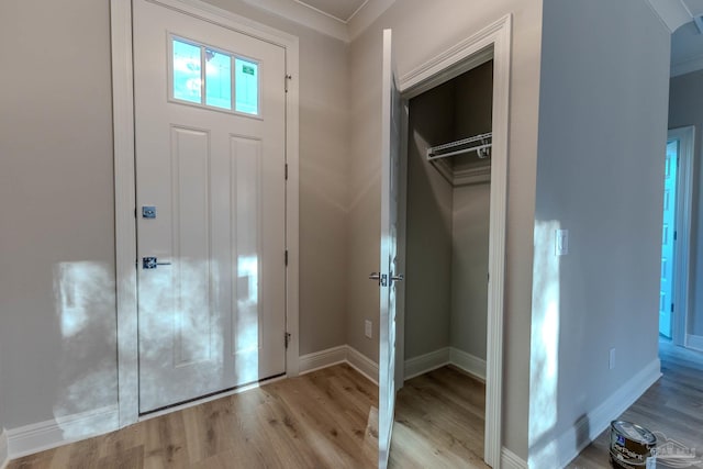 foyer entrance with crown molding and light wood-type flooring