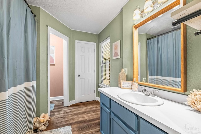 bathroom with vanity, hardwood / wood-style floors, a textured ceiling, and walk in shower