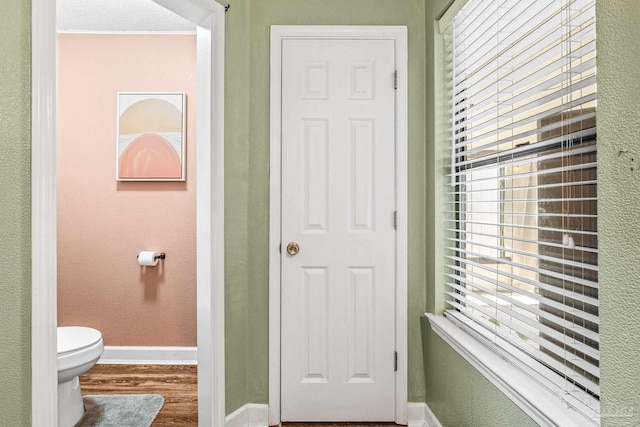 bathroom featuring hardwood / wood-style flooring and toilet