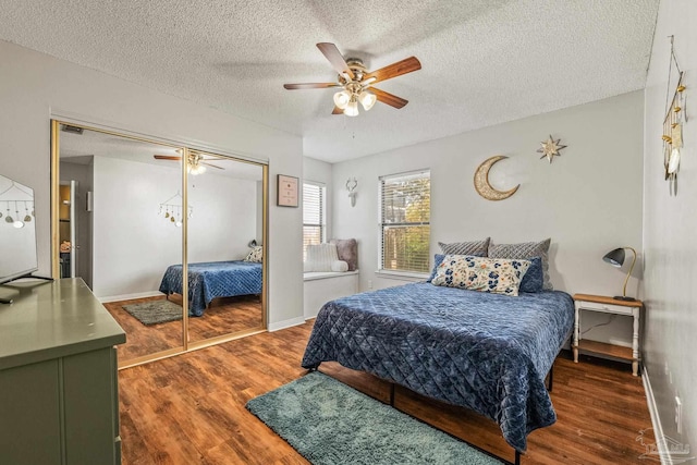 bedroom with dark hardwood / wood-style flooring, a textured ceiling, a closet, and ceiling fan