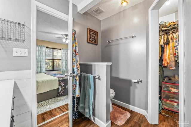 bathroom featuring hardwood / wood-style floors, toilet, a textured ceiling, and ceiling fan