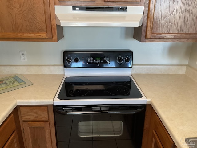 kitchen featuring electric range and range hood