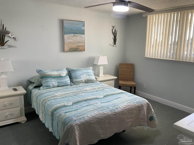 bedroom with ceiling fan, dark carpet, and a textured ceiling