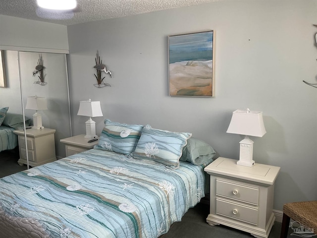 bedroom with dark colored carpet, a textured ceiling, and a closet