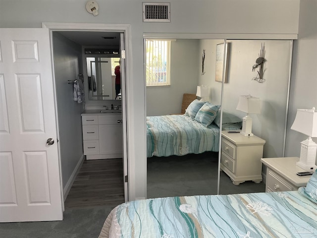 carpeted bedroom featuring a closet and sink