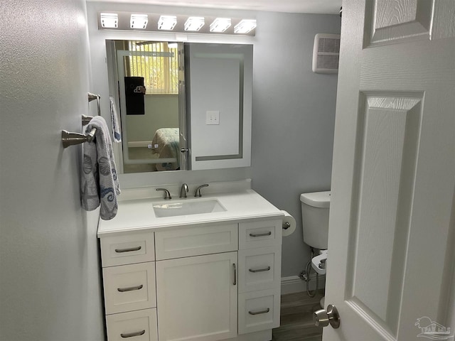 bathroom featuring vanity, toilet, and a wall unit AC