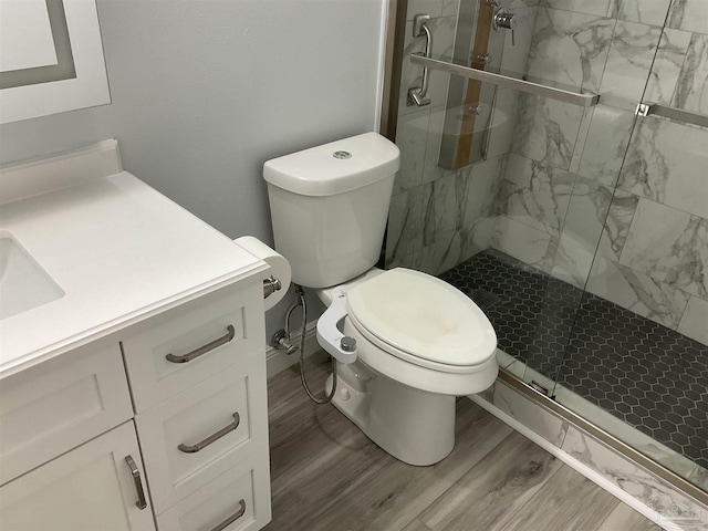 bathroom featuring vanity, hardwood / wood-style flooring, toilet, and a shower with shower door