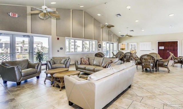 tiled living room featuring ceiling fan, high vaulted ceiling, and french doors